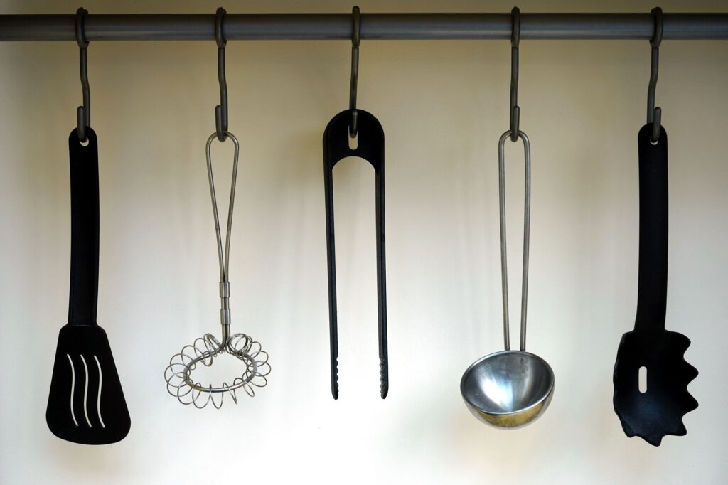 Kitchen utensils hanging from a wall rail to free up drawer space
