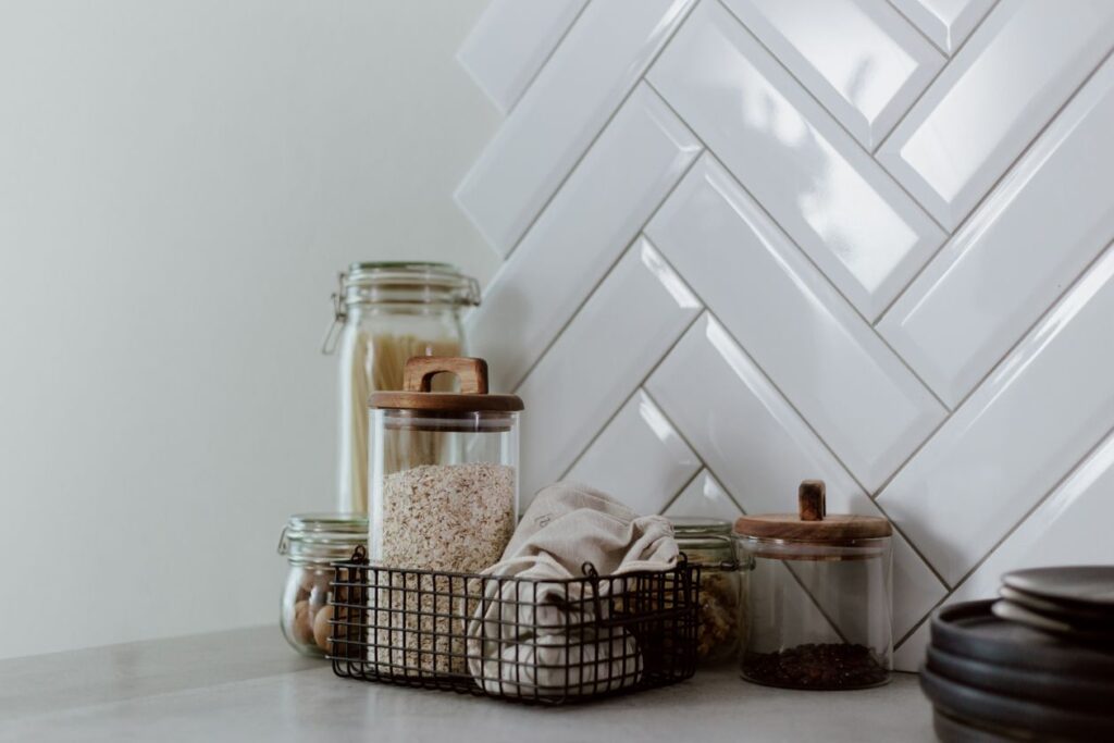 Stylish kitchen setup featuring glass jars with pasta and grains on a clean counter